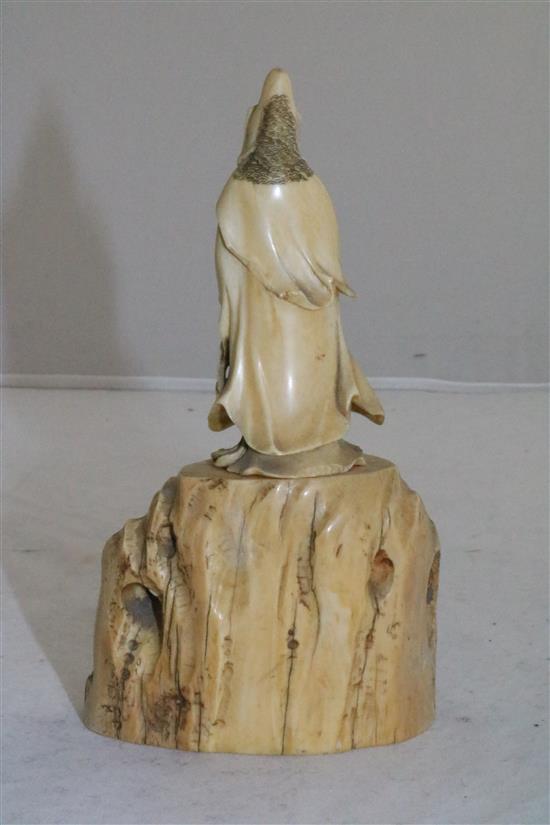 A Japanese ivory figure of Kwannon standing on rockwork, early 20th century, 14.5cm